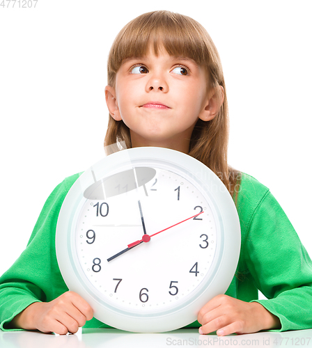 Image of Little girl is holding big clock