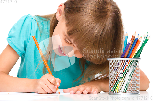 Image of Little girl is drawing using pencils