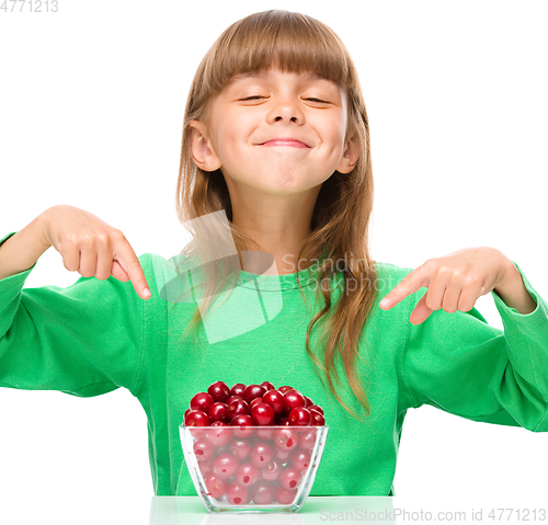 Image of Cute girl is eating cherries