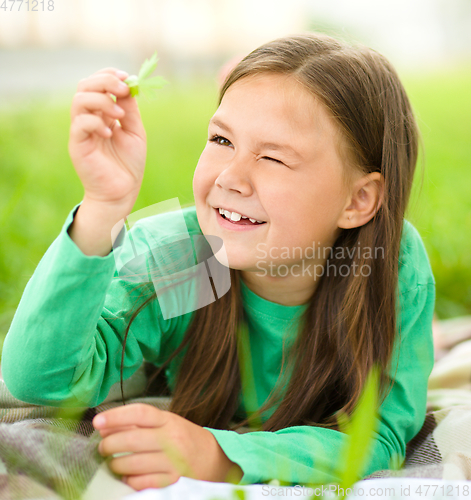 Image of Portrait of a little girl laying on green grass