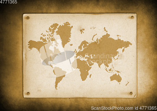 Image of Vintage world map parchment nailed to a wall