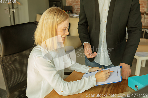 Image of A young businesswoman moving in office, getting new work place