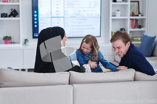 Image of Happy Muslim family spending time together in modern home