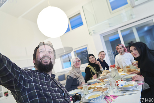 Image of Muslim family taking selfie while having iftar together during Ramadan