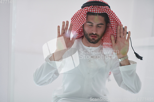 Image of Muslim man doing sujud or sajdah on the glass floor