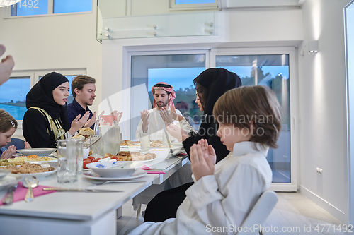 Image of Muslim family making iftar dua to break fasting during Ramadan.