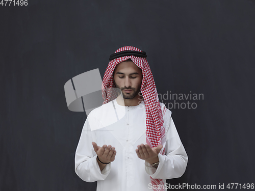 Image of Arab man in traditional clothes praying to God or making dua