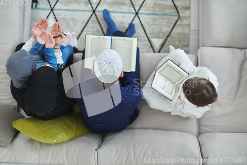 Image of Top view of young muslim family reading Quran during Ramadan