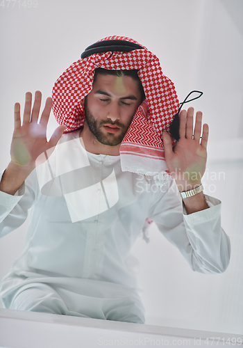 Image of Muslim man doing sujud or sajdah on the glass floor