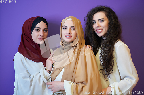 Image of Young muslim women posing on purple background