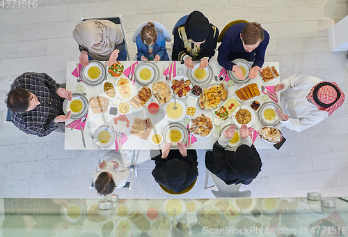 Image of Top view of Muslim family making iftar dua to break fasting during Ramadan.