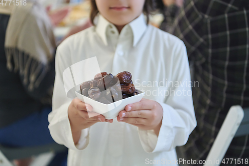 Image of Arabian kid in the traditional clothes during iftar