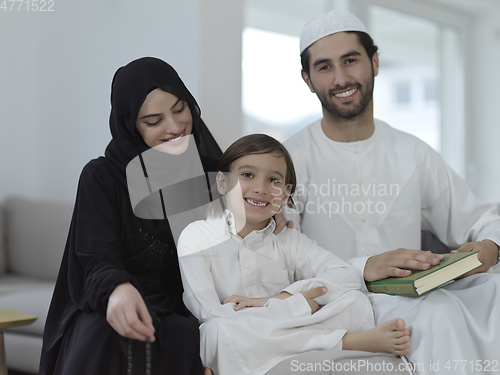 Image of Young muslim family reading Quran during Ramadan