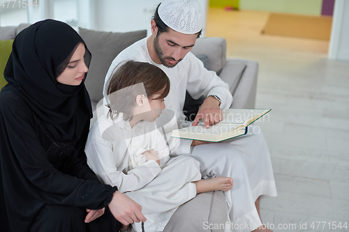 Image of Young muslim family reading Quran during Ramadan