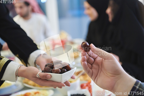 Image of Muslim family starting iftar with dates during Ramadan