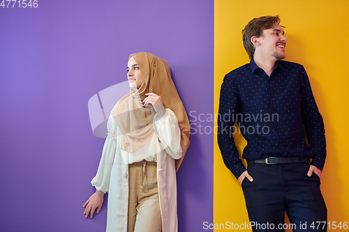 Image of Portrait of happy young muslim couple standing isolated on colorful background