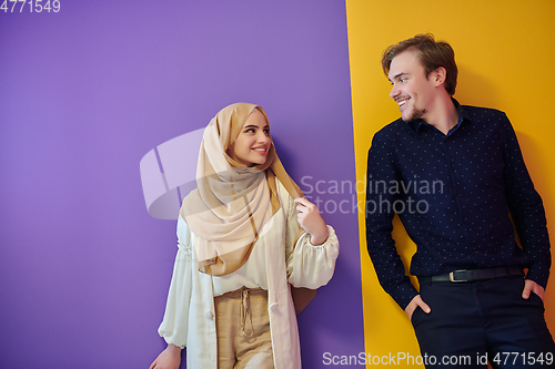 Image of Portrait of happy young muslim couple standing isolated on colorful background