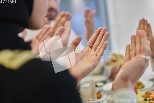 Image of Muslim family making iftar dua to break fasting during Ramadan