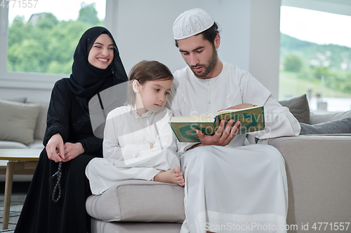 Image of Young muslim family reading Quran during Ramadan