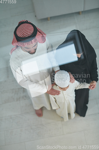 Image of Top view of young arabian muslim family wearing traditional clothes