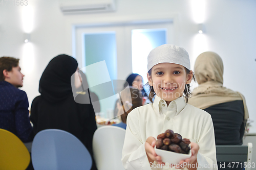 Image of Arabian kid in the traditional clothes during iftar