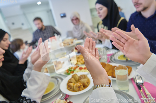 Image of Muslim family making iftar dua to break fasting during Ramadan.