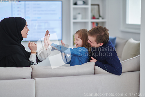 Image of Happy Muslim family spending time together in modern home