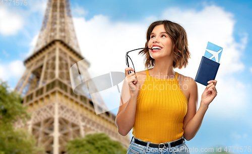 Image of happy woman with air ticket over eiffel tower
