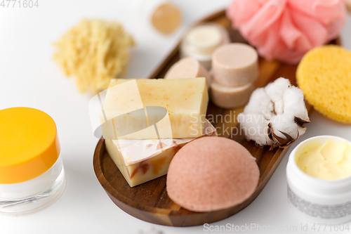 Image of crafted soap, sponge and wisp on wooden tray
