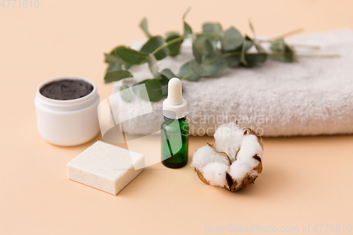 Image of serum, clay mask, oil and eucalyptus on bath towel