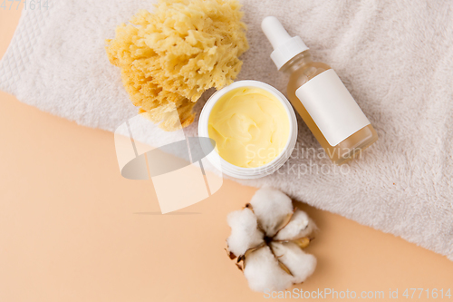 Image of body butter, essential oil, sponge on bath towel