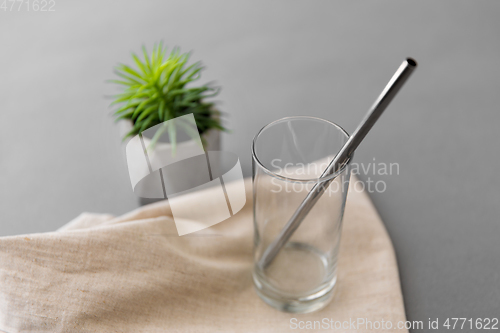 Image of empty glass mug of with reusable metallic straw