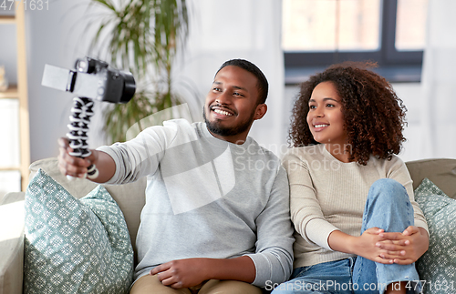 Image of couple of video bloggers with camera at home