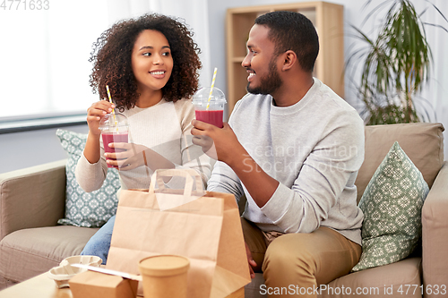 Image of happy couple with takeaway food and drinks at home