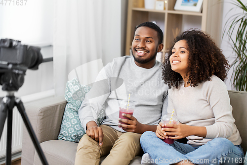 Image of couple of video bloggers with camera at home