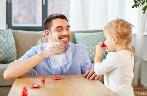 Image of father and daughter playing tea party at home