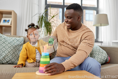 Image of african family playing with baby daughter at home