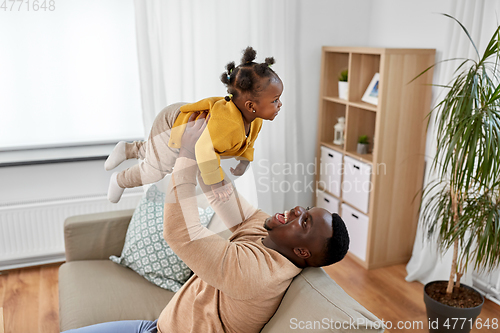 Image of happy african american father with baby at home