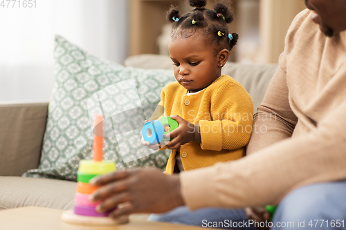 Image of african family playing with baby daughter at home