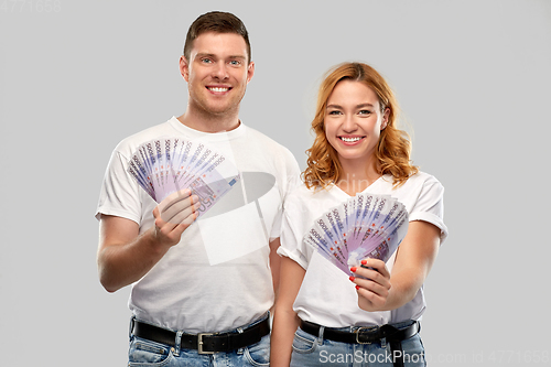 Image of happy couple in white t-shirts with euro money