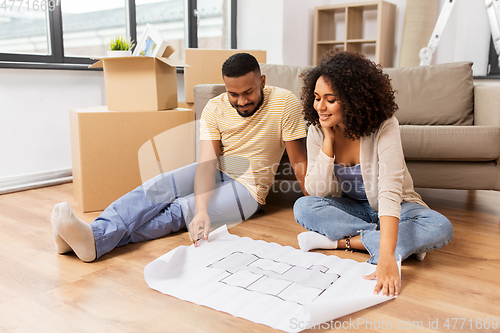 Image of couple with boxes and blueprint moving to new home