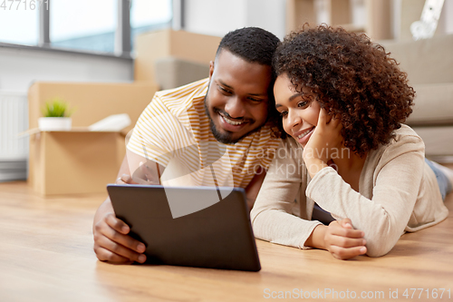 Image of happy couple with tablet pc computer at new home