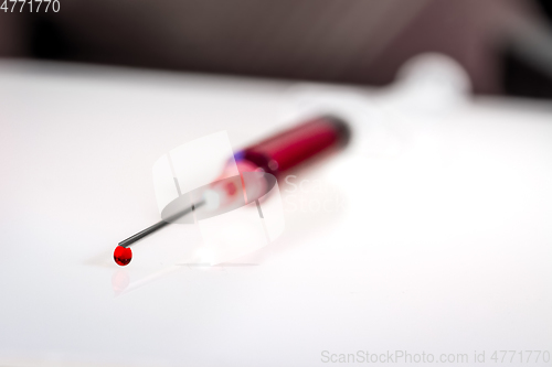 Image of Syringe needle with blood macro view