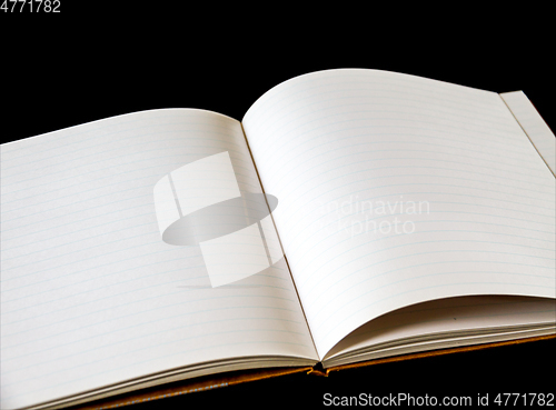 Image of Open blank notebook on black background