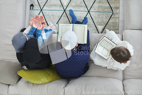 Image of Top view of young muslim family reading Quran during Ramadan