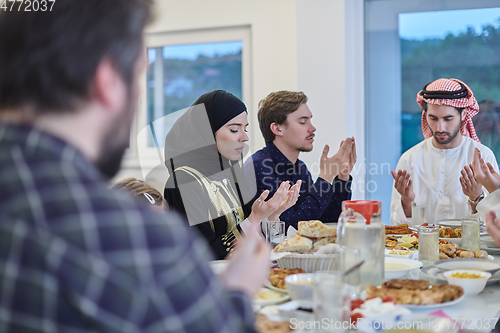 Image of Muslim family making iftar dua to break fasting during Ramadan.