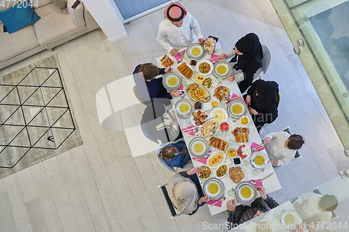 Image of Top view of Muslim family making iftar dua to break fasting during Ramadan.