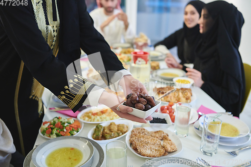 Image of Muslim family starting iftar with dates during Ramadan