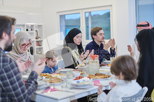 Image of Muslim family making iftar dua to break fasting during Ramadan.