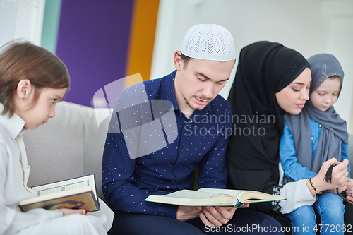 Image of Young muslim family reading Quran during Ramadan